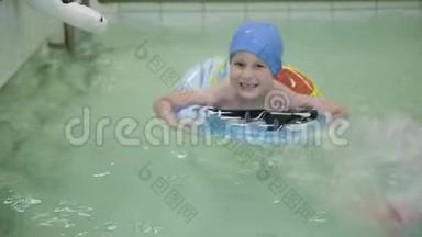 带着橡胶<strong>圈</strong>的男孩在游<strong>泳</strong>池里。 小女孩漂浮在游<strong>泳</strong>池里的橡胶<strong>圈</strong>上。